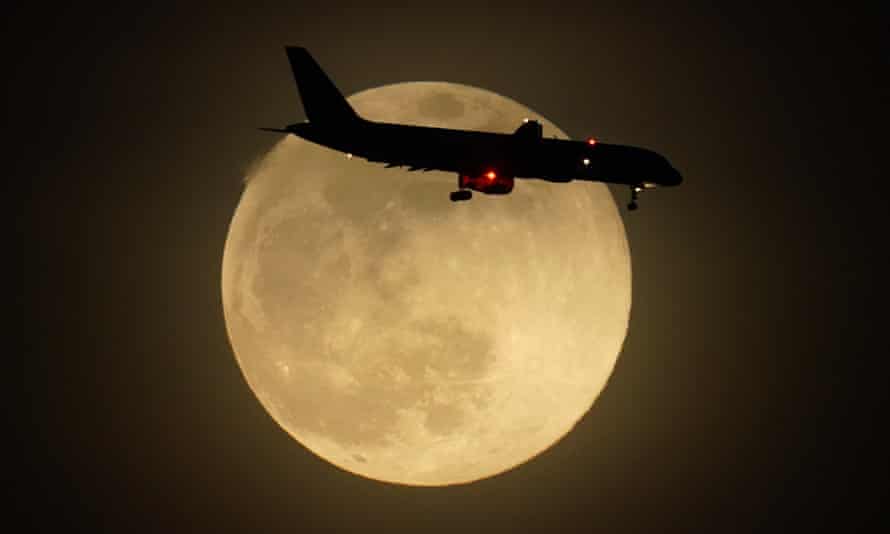 Sylwetka samolotu przy wschodzącym księżycu zbliżającego się w poniedziałek do międzynarodowego lotniska Louisville w Kentucky.