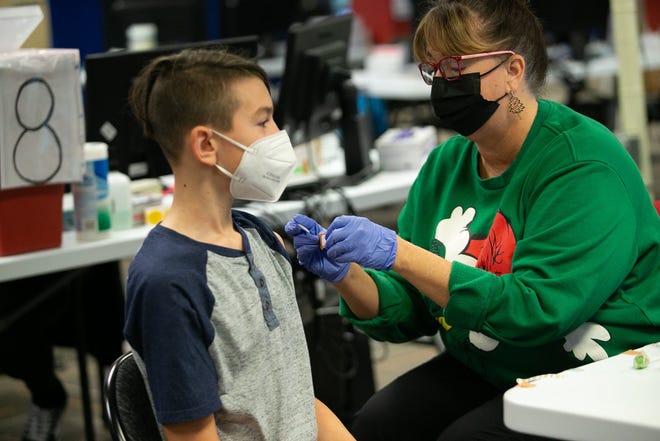 Tamera Huff, pracownica CPOC, zakłada bandaż na 11-letniego Aidena Turnera po tym, jak w sobotę po cichu otrzymała dawkę Pfizera w Central Ohio Primary Care w Westerville.