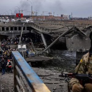 Un grupo de evacuados avanza junto a un puente destruido en Irpín, al norte de Kiev. Foto: Dimitar DILKOFF/AFP, vía: La Nación.