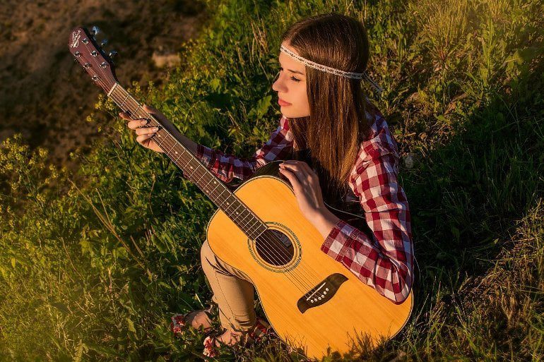 Przedstawia kobietę grającą na gitarze